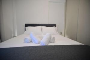 un letto con cuscini bianchi e asciugamani blu di Poly's Home 2 a Ioannina