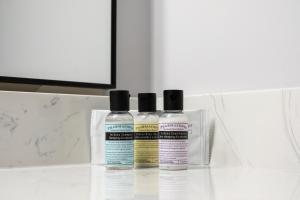 three bottles of moisturizers sitting on a bathroom counter at Copper Mountain Inn and Suites in Princeton