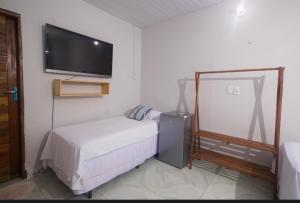 a bedroom with a bed and a flat screen tv at Canoa Hospedagem in Barra Grande