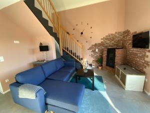 a living room with a blue couch and a brick fireplace at Well-being in Eifel in Nettersheim