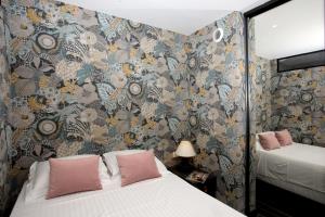 um quarto com 2 camas e um papel de parede floral em Appartement 5 min des plages Croisette em Cannes