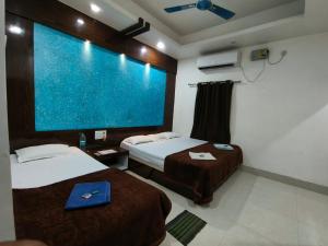 a hotel room with two beds and a large screen at Hotel Bobby house in Puri