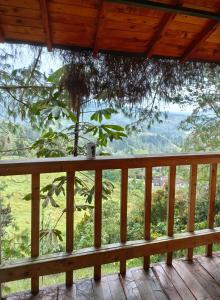 porche de madera con vistas a un árbol en Waira home, en Guarne