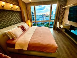 a large bed in a hotel room with a large window at Lux SL Luxury Style of Life in Pattaya Central
