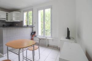 eine Küche mit einem Tisch, einem kleinen Tisch und einem Tisch in der Unterkunft Montrouge 1 Bedroom Flat 30m2 - (2 pièces) in Montrouge