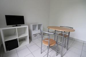 a room with a table and two stools and a television at Montrouge 1 Bedroom Flat 30m2 - (2 pièces) in Montrouge