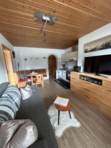 a living room with a couch and a kitchen at Appartement Bergblick in Brixen im Thale