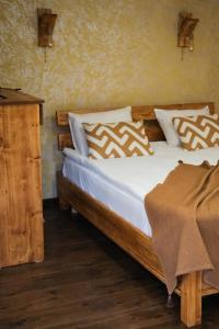 a bedroom with a wooden bed with white sheets and pillows at EcoLife Lodge Hotel & Restaurant in Stepʼanavan