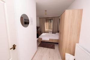 een slaapkamer met een wit bed en een houten deur bij Complex Stoican in Băile Herculane