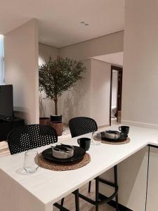 a kitchen counter with two chairs and a table at Luxury apartment with self check-in in Riyadh