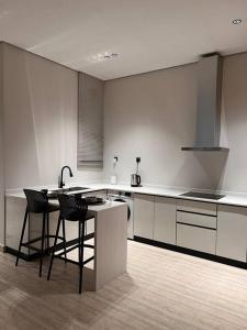 a kitchen with a counter and some chairs in it at Luxury apartment with self check-in in Riyadh