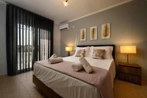 a bedroom with a large bed with two pillows on it at Villa Alina in Lefkimmi