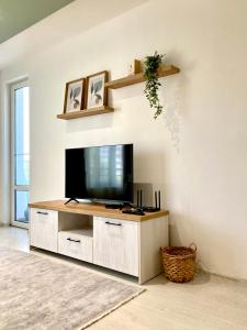 een woonkamer met een flatscreen-tv aan de muur bij Уютен кът in Boergas