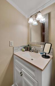 a bathroom with a sink and a mirror at The Farmhouse 20 Min to Magnolia and Baylor in Waco