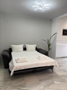 a white bedroom with a bed with a white ceiling at Luxury apartment Benalmadena First line in Benalmádena