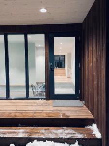 uma porta aberta de uma casa com um deque de madeira em Single room em Trondheim