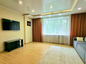 a living room with a couch and a large window at Yanko in Kokshetau