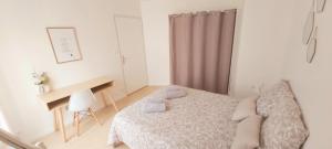 a white bedroom with a bed and a desk at Le Petit Martin ~T2 cosy ~ Netflix ~ Parking ~ Animaux bienvenus 