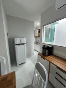 eine Küche mit einem Kühlschrank sowie einem Tisch und Stühlen in der Unterkunft STILLO AÇAI in Bragança