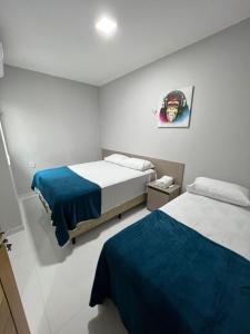 sypialnia z 2 łóżkami i zdjęciem na ścianie w obiekcie STILLO AÇAI w mieście Bragança