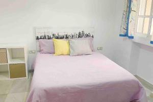 ein Schlafzimmer mit einem großen weißen Bett mit bunten Kissen in der Unterkunft 4 Bedroom House in City Centre with Your Own Private Roof Terrace in Málaga