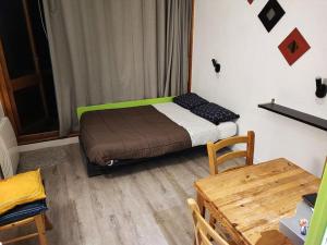 une petite chambre avec un lit avec une tête de lit verte dans l'établissement Arc 1800 - Studio 5p - Réservations du Samedi au Samedi uniquement, à Arc 1800