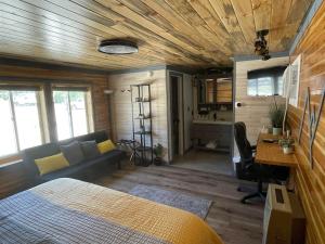a bedroom with a bed and a couch and a desk at The Whispering Elms Motel in Baker