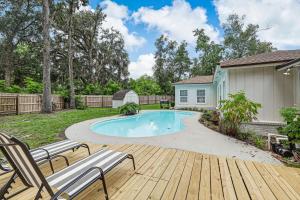 a backyard with a swimming pool and a wooden deck at Lake View Retreatpool10qn Beds in Orange Park