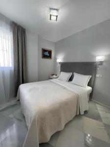 una camera da letto con un grande letto bianco con due cuscini di Luxury apartment Benalmadena First line a Benalmádena