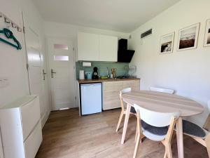 a kitchen with a table and chairs in a room at Domek letniskowy Ińsko BIO BOX in Ińsko +3 photos