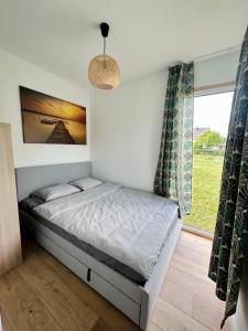 a bedroom with a bed and a window at Domek letniskowy Ińsko BIO BOX in Ińsko +2 photos