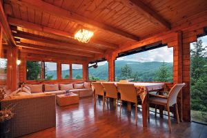 a wooden living room with a table and chairs at Cabana Poiana Verde in Slănic-Moldova
