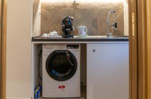 a washing machine under a counter in a kitchen at INSULA LUBRENSIS flat in Massa Lubrense