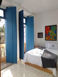 1 dormitorio con puertas azules y 1 cama. en Pouso das Artes Cachoeira-hospedaria e espaço cultural, en Campinas