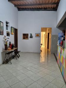 uma sala de estar com uma mesa e piso em azulejo em Pouso das Artes Cachoeira-hospedaria e espaço cultural em Campinas