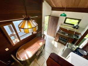 uma sala de estar com um banco e uma televisão em Casa Selva - Vila do Abraão - Ilha grande em Abraão
