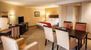Pretoria的住宿－南孫比勒陀利亞酒店，酒店客房带一张床、一张桌子和椅子