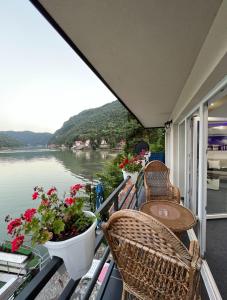 a balcony with two chairs and a table and flowers at Vikendica Teodora - Zvornik in Zvornik