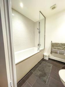 a bathroom with a tub and a toilet and a sink at Apartment Central London in London