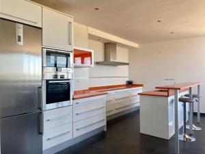 a kitchen with white cabinets and a wooden counter top at Casacastillo28 in Peñarroya de Tastavins