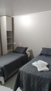 ein Schlafzimmer mit 2 Betten und einem weißen Hemd darüber in der Unterkunft Flat beach class muro alto in Porto De Galinhas