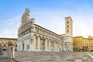 a large stone building with a tower and a church at FRONTE MURA LUCCA - Parcheggio - WiFi Il CORTIGIANO in Lucca