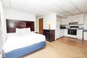 a bedroom with a large bed and a kitchen at Brentwood Motor Inn in Marquette