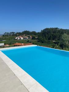 a large swimming pool with a blue at CASA DAS QUINTÃES in Figueiredo
