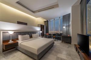 a hotel room with a bed and a television at Hadab Al Sahafa in Riyadh
