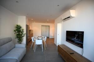 a living room with a couch and a table with chairs at Duerming Sanxenxo Silgar VUT in Sanxenxo