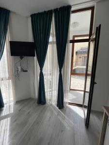 uma sala de estar com cortinas azuis e um espelho em Studio Maria Balchik em Balchik