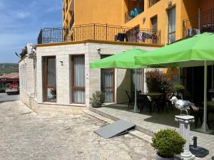 a bird sitting on a stool under a green umbrella at Studio Maria Balchik in Balchik