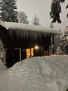 a house with icicles hanging from the roof at Skikoliba 1 in Jahorina
