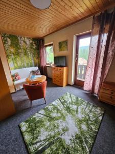 a living room with a table and a bed and a window at Pension Schatzkisterl in Zwiesel